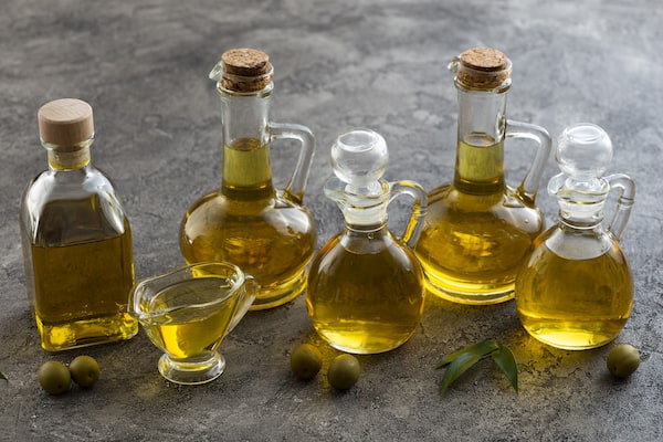 bouteilles d'huile d'olive sur fond gris pierre